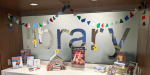 Christmas and winter-themed books are on display at the Main Library's alcove. Festive and colorful felt garland is hung from its ceiling, along with yellow and red Cricut-cut stars. There is a book Christmas tree and Christmas books on display, as well as cookie cutters made at the LPCPL Exchange with appropriate signage next to them.